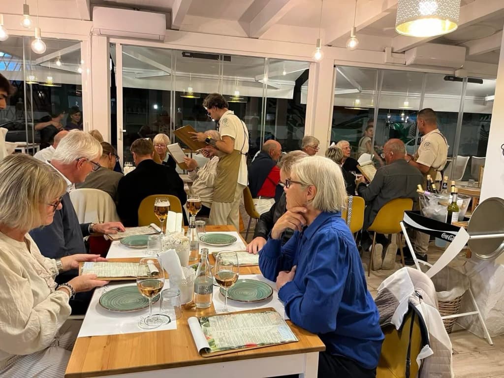Guests reading the menu at a restaurant in Cabanas whilst staff take orders